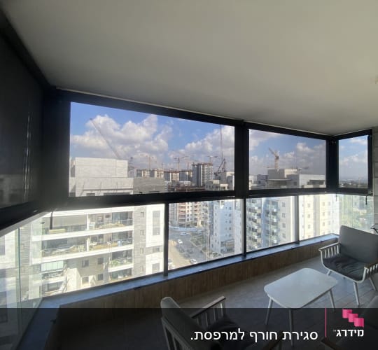 מרפסת עם סוככים כהים נגללים על חלונות